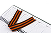 St. George ribbon lies on piece of open diary | Stock Foto