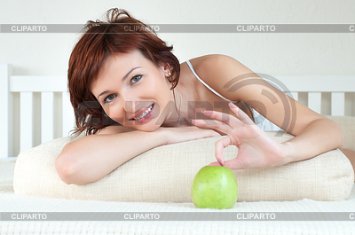 Atractiva mujer joven con una manzana verde en la cama | Foto de alta resolución |ID 3666216