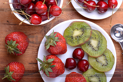 Frucht mit Kirsche, Erdbeere, Kiwi auf Holzplatte | Foto mit hoher Auflösung |ID 5432713